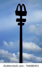 Aprilia, Italy - Aug 2015: Silhouette Of Mac Donald Signpost Against Blue Sky