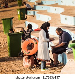 Aqaba, Jordan, March 7, 2018: Jordanian Couple With A Pram On The Stone Stairs At The Main Beach Of Aqaba, Middle East