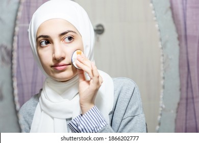 Arab Beautiful Woman Cleaning Her Face With Cotton Swab And Looking At The Mirror