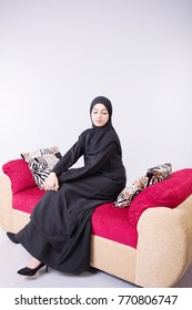 Arab Beautiful Woman Sitting On Sofa At Home With White Background