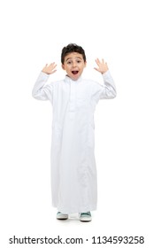 Arab Boy Surprised, Wearing White Traditional Saudi Thobe And Sneakers, Raising His Hands On White Isolated Background