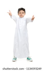 Arab boy winking and acting cool with crossed hands, wearing white traditional Saudi Thobe and sneakers, on white isolated background