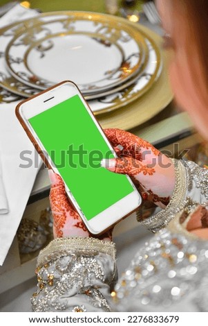 An Arab bride holds a phone on her wedding night