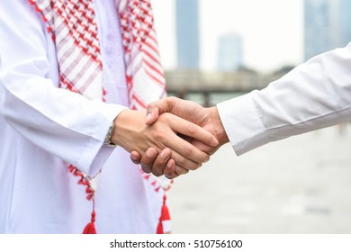 Arab And Business Man Are Shaking Hand On Cityscape Background