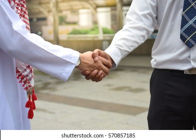 Arab And Business Man Are Shaking Hand On Cityscape Background