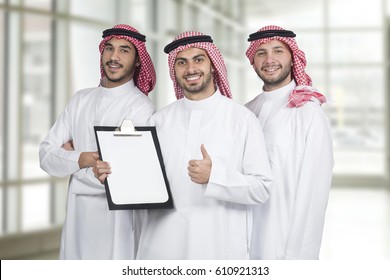 Arab Business People In A Meeting, Three Business People Standing In A Modern Office Holding A Folder For Presentation, Ethnic Business People, Business Team.