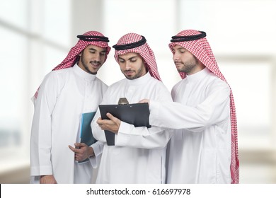 Arab Business People In A Meeting, Three Business People Standing In A Modern Office Interior Discussing Work, Ethnic Business People, Business Team.