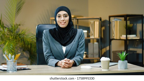 Arab business woman in office. Beautiful happy Arabic Emirati lady in hijab at office workplace. 