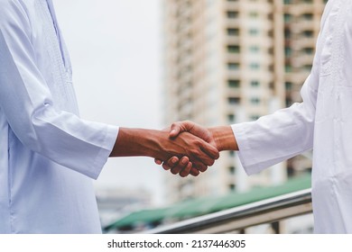 Arab Businessman Muslim Dress Shaking Hands Together. Muslim Men Teamwork Business Partner Handshake With Business Partnership. Close Up Hand UAE Diversity Multiracial People Trust Honesty Commitment