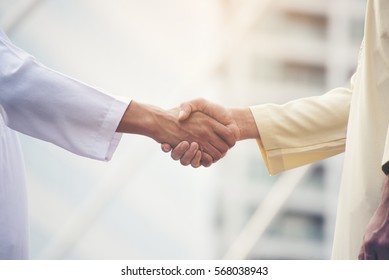 Arab Businessman Shaking Hands Together. Teamwork Business Partner Wear Muslim Dress Shake Hands With Partnership Concept. Success Diversity People Trust Each Other And Commitment Handshake.