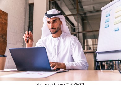Arab businessman wearing traditional emirates kandura at work in a Dubai international company