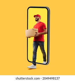 Arab Courier Guy Coming Out Of Big Phone Screen Carrying Parcel Box Delivering Package Over Yellow Studio Background. Delivery Service, Mobile App For Your Smartphone. Square Shot - Shutterstock ID 2049498137