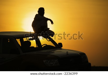 Arab driver sitting on the top of his overland car