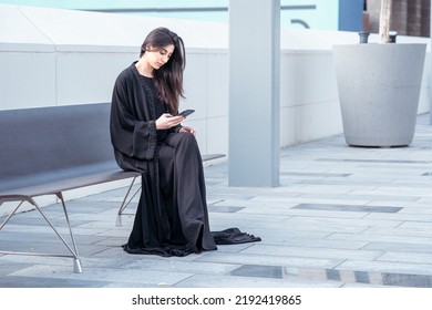 Arab Emirati Business Woman Working On Her Phone Wearing Abaya Outdoor