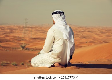 Arab Emirati Man Sitting On Top Of A Dune In UAE Desert 