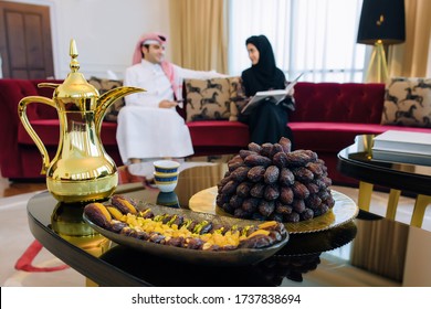 An Arab family in traditional dress eats dates and drinks tea (Ramadan. eid al adha). Feast in honor of Eid Mubarak. The family sits on a background of plates with dates, dried fruits - Shutterstock ID 1737838694