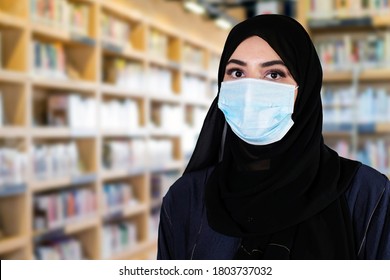 Arab Girl Student Wearing Protective Face Mask  And Traditional Clothing At A School Library. Young Middle Eastern Lady Protecting Herself From Airborne Virus