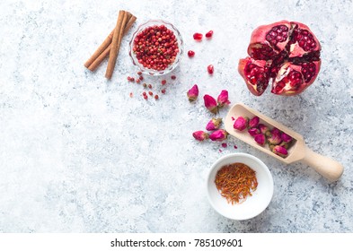 Arab ingredients, middle eastern food. Space for text. Arabic cuisine ingredients, white concrete background. Rose buds, spices, pomegranate, pepper. Halal food making. Top view. Arab food concept