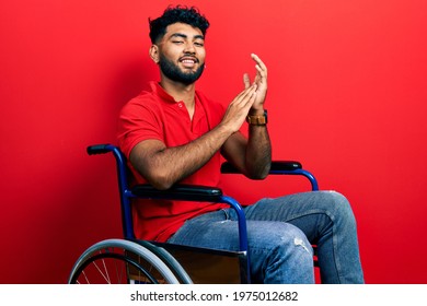 Arab Man With Beard Sitting On Wheelchair Clapping And Applauding Happy And Joyful, Smiling Proud Hands Together 