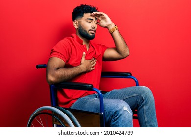 Arab man with beard sitting on wheelchair touching forehead for illness and fever, flu and cold, virus sick 