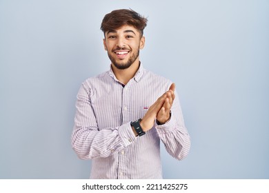 Arab Man With Beard Standing Over Blue Background Clapping And Applauding Happy And Joyful, Smiling Proud Hands Together 