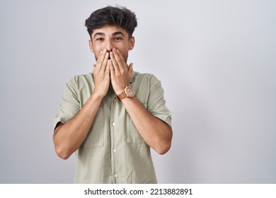 Arab Man With Beard Standing Over White Background Laughing And Embarrassed Giggle Covering Mouth With Hands, Gossip And Scandal Concept 