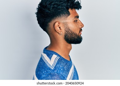 Arab Man With Beard Wearing Casual Striped T Shirt Looking To Side, Relax Profile Pose With Natural Face With Confident Smile. 