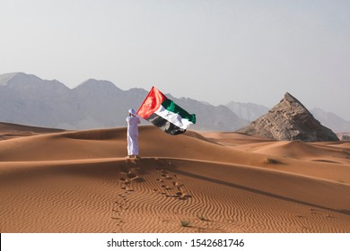 Arab Man Holding The UAE Flag In The Desert Celebrating UAE National Day And Uae Flag Day.