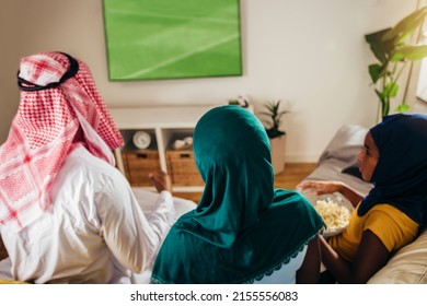 Arab Man Looking TV At Home During A Sport Event With His Family. Watching Football Game.