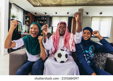 Arab Man Looking TV At Home During A Sport Event With His Family. Watching Football Game.