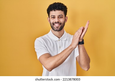 Arab Man Standing Over Yellow Background Clapping And Applauding Happy And Joyful, Smiling Proud Hands Together 