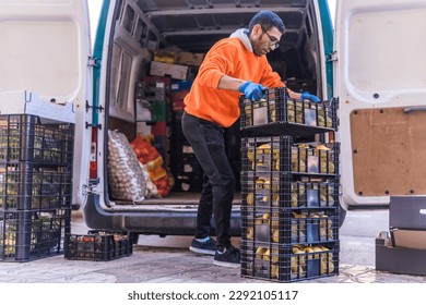 arab man taking boxes of fruit from the van