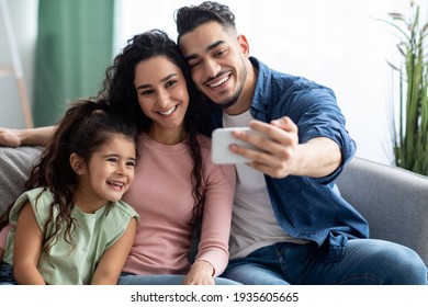 Arab Man Taking Selfie On Smartphone With Wife And Daughter At Home - Powered by Shutterstock