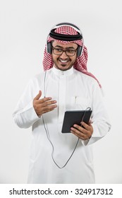 Arab Man Using Digital Tablet And Listening Music On Headphones