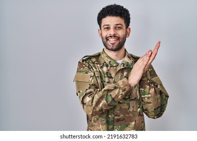 Arab Man Wearing Camouflage Army Uniform Clapping And Applauding Happy And Joyful, Smiling Proud Hands Together 