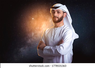 Arab Man Wearing Kandoura With Crossing Arms And Standing Front Galaxy Background, UAE To Mars, Space Concept. 