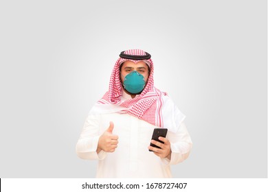 Arab Man Wearing Medical Face Mask Protecting Himself From Coronavirus, Isolated On Gray Background.
