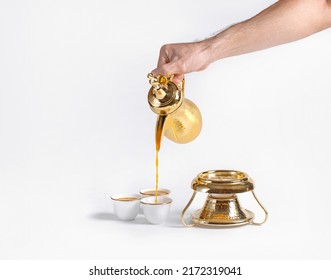 An Arab Man In White Kandura Serving Arabic Coffee And Dalah