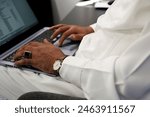 Arab man working on laptop in the office, following stock market