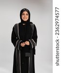 Arab middle eastern Saudi woman in Hijab and traditional formal Abaya, on white isolated background, with different poses, expressions, hand and gestures, studio lighting