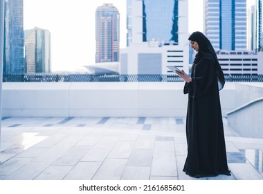 Arab Muslim Business Woman Working On Tablet In Outdoor Meeting. Arabian Saudi Or Emirati Lady Businesswoman Wearing Abaya 