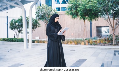 Arab Muslim Business Woman Working On Tablet In Outdoor Meeting. Arabian Saudi Or Emirati Lady Businesswoman Wearing Abaya 