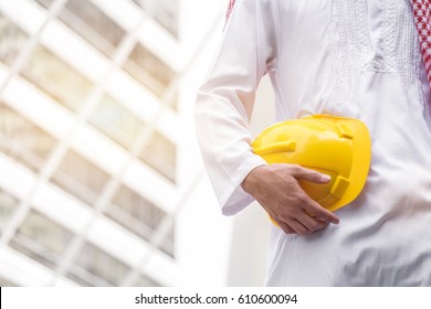 Arab Muslim Engineer Uniform And Worker Checking Construction Drawing At Construction Site. And Space For Your Text