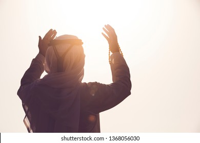 Arab Muslim man pray and doing Duaa under sunrise light, Islamic religion and Ramadan Kareem concept.