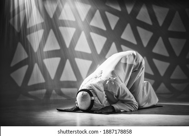 arab muslim prayer worship and praying for allah blessing in islamic mosque. arab muslim is on his knees praying during holy month of ramadan in black and white tone