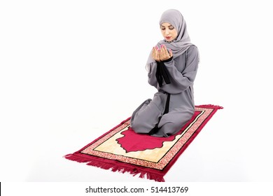 Arab Muslim Woman Praying On A Praying Carpet. Isolated On White Background