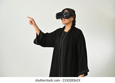 Arab Muslim woman with VR headset playing or watching virtual reality and pointing or clicking. innovation concept - Powered by Shutterstock