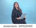 Arab Saudi or Emirati woman wearing Abaya using tablet working or reading. Arabian brunette girl happy thumbs up on blue background