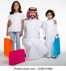 Arab Saudi family at the mall with colored shopping bags, on white isolated background, ready for cutout and design purposes.