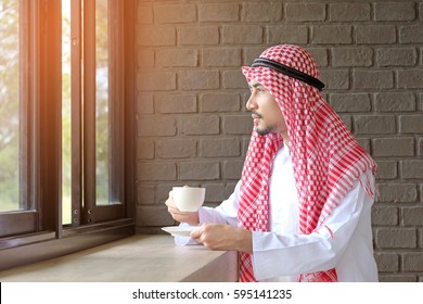 Arab Saudi Man Drink Coffee  In Coffee Shop And Look At View Outside The Window .